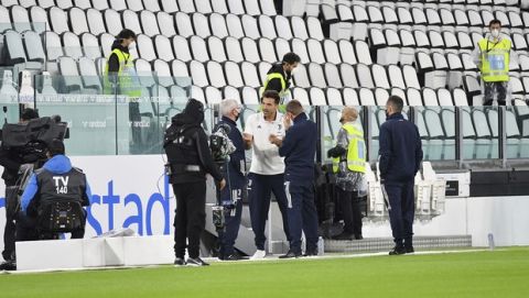 Juventus goalie Gianluigi Buffon, centre, stands on the pitch of the Allianz Stadium in Turin, Italy, Sunday, Oct. 4, 2020 ahead of the scheduled Serie A soccer match between Juventus and Napoli. Napoli is likely to be handed a 3-0 loss by the Italian leagues judge for failing to show for its Serie A match at Juventus on Sunday night. Napoli did not travel to Turin for the match after local health authorities ordered the squad into quarantine after two players tested positive for the coronavirus. (Tano Pecoraro/LaPresse via AP)
