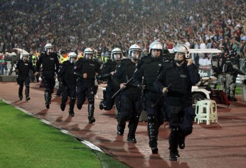 Serbian riot policemen arrive to secure the pitch after a flag with Albanian national symbols was flown by a remotely operated drone during the UEFA Euro 2016 group I qualifying football match between Serbia and Albania in Belgrade on October 14, 2014. A Euro 2016 qualifying tie between Serbia and Albania was abandoned after a drone carrying a pro-Albanian message was flown over the stadium, sparking violent scenes on and off the pitch. AFP PHOTO / GENT SHKULLAKUGENT SHKULLAKU/AFP/Getty Images