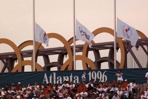 Olympic flags fly at half staff at the Olympic Stadium during the second day of athletics competition at the 1996 Summer Olympics in Atlanta, Saturday, July 27, 1996.  Olympic flags throughout the city will fly at half staff following a deadly explosion at Centennial Olympic Park earlier on Saturday. (AP Photo/Doug Mills)