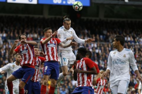 Real Madrid's Gareth Bale, top right, out jumps Atletico Madrid's Saul Niguez, top left, during the Spanish La Liga soccer match between Real Madrid and Atletico Madrid at the Santiago Bernabeu stadium in Madrid, Sunday, April 8, 2018. (AP Photo/Francisco Seco)