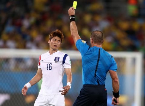 CUIABA, BRAZIL - JUNE 17:  Ki Sung-Yueng of South Korea is shown a yellow card by referee Nestor Pitana during the 2014 FIFA World Cup Brazil Group H match between Russia and South Korea at Arena Pantanal on June 17, 2014 in Cuiaba, Brazil.  (Photo by Warren Little/Getty Images)