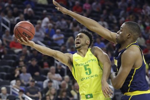 Oregon's Tyler Dorsey shoots around California's Kingsley Okoroh during the first half of an NCAA college basketball game in the semifinals of the Pac-12 tournament Friday, March 10, 2017, in Las Vegas. (AP Photo/John Locher)