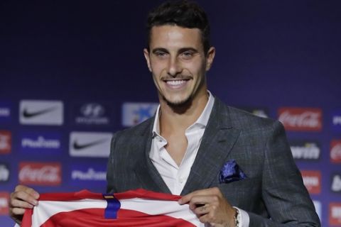 Mario Hermoso holds up his new shirt after signing for Atletico Madrid from Espanyol during his official presentation at the Wanda Metropolitano Stadium, Madrid, Thursday July 18, 2019. (AP Photo/Manu Fernandez)