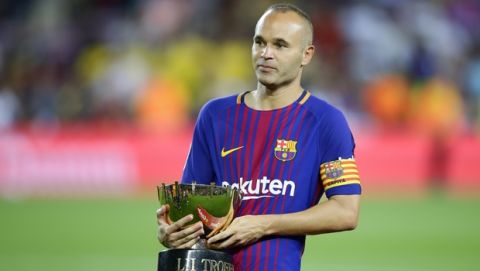 FC Barcelona's Andres Iniesta holds the Joan Gamper trophy after a friendly soccer match between FC Barcelona and Chapecoense at the Camp Nou stadium in Barcelona, Spain, Monday, Aug. 7, 2017. FC Barcelona defeated Chapecoense. (AP Photo/Manu Fernandez)