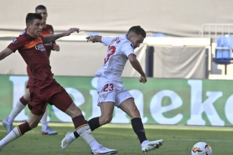 Sevilla's Sergio Reguilon, right, scores his side's first goal during the Europa League, round of 16 soccer match between Roma and Sevilla, at the Schauinsland-Reisen-Arena in Duisburg, Germany, Thursday, Aug. 6, 2020. (Wolfgang Rattay/Pool Photo via AP)
