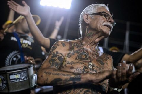 TO GO WITH AFP STORY by Javier Tovar
Brazilian football club Botafogo fan Delneri Martins Viana, a 69-year-old retired soldier, cheers for the team during a match at Sao Genario stadium in Rio de Janeiro, Brazil, on January 21, 2014. Delneri has 83 tattoos on his body dedicated to Botafogo and describes himself as the club's biggest fan.   AFP PHOTO / YASUYOSHI CHIBA