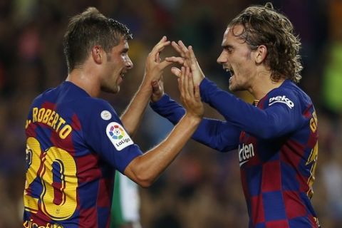 Barcelona's Antoine Griezmann, right, celebrates after scoring with his teammate Barcelona's Sergi Roberto his side's first goal during the Spanish La Liga soccer match between FC Barcelona and Betis at the Camp Nou stadium in Barcelona, Spain, Sunday, Aug. 25, 2019. (AP Photo/Joan Monfort)