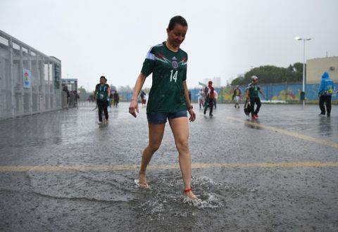 NATAL, BRAZIL - JUNE 13: A Mexico fan wades through rain water before the 2014 FIFA World Cup Brazil Group A match between Mexico and Cameroon at Estadio das Dunas on June 13, 2014 in Natal, Brazil.  (Photo by Matthias Hangst/Getty Images)
