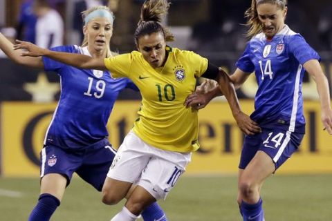 FILE- In this Oct. 21, 2015, file photo, Brazil's Marta (10) works to get to the ball between the United States' Julie Johnston (19) and Morgan Brian (14) during the first half of an international friendly soccer match in Seattle. The 30-year old Brazilian striker was named FIFA Player of the Year for five consecutive years from 2006 to 2010. Yet despite her success, she is not a household name in her country, where the focus will be on Neymar and the mens squad to win their first Olympic gold.   (AP Photo/Elaine Thompson, File)
