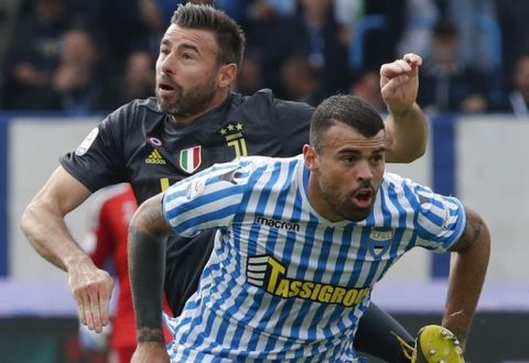 Juventus' Andrea Barzagli, top, and Spal's Andrea Petagna vie for the ball during the Serie A soccer match between Spal and Juventus, at the Paolo Mazza stadium in Ferrara, Italy, Saturday, April 13, 2019. (AP Photo/Antonio Calanni)