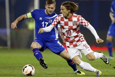FILE - In this Nov. 19, 2013, file photo, Iceland's Aron Gunnarsson, left, is challenged by Croatia's Luka Modric during their World Cup qualifying playoff second leg soccer match in Zagreb, Croatia. (AP Photo/Darko Bandic,File)