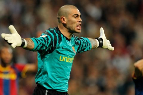 Barcelona's goalkeeper Victor Valdes, reacts while receiving a yellow card during his Spanish La Liga soccer match against Barcelona at the Santiago Bernabeu stadium in Madrid, Saturday, April 16, 2011. (AP Photo/Arturo Rodriguez)