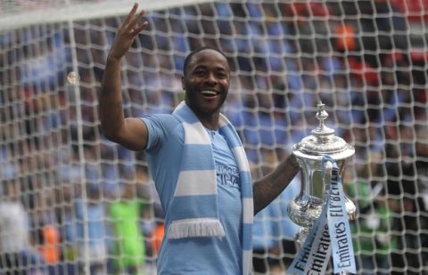 Manchester City's Raheem Sterling celebrates with the trophy after the English FA Cup Final soccer match between Manchester City and Watford at Wembley stadium in London, Saturday, May 18, 2019. (AP Photo/Kirsty Wigglesworth)