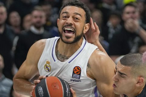 Real Madrid's Nigel Williams-Goss, left, drives to the basket as Partizan's Yam Madar tries to block him during the Euroleague basketball match between Partizan and Real Madrid, in Belgrade, Serbia, Tuesday, May 2, 2023. (AP Photo/Darko Vojinovic)