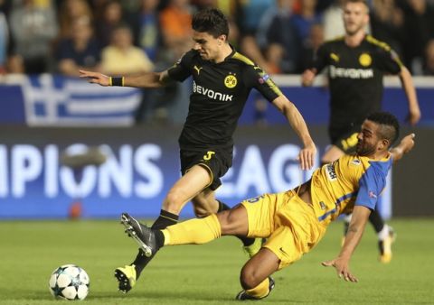 Dortmund's Marc Bartra, left, and APOEL Nicosia's Lorenzo Ebecilio challenge for the ball during the Champions League Group H soccer match between APOEL Nicosia and Borussia Dortmund at GSP stadium, in Nicosia, Cyprus, on Tuesday, Oct. 17, 2017. (AP Photo/Petros Karadjias)