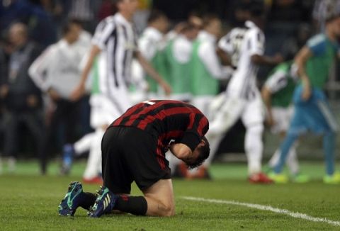 AC Milan's Davide Calabria lies on the pitch as Juventus players celebrate in background after Juventus' Medhi Benatia scored, during the Italian Cup final soccer match between Juventus and AC Milan, at the Rome Olympic stadium, Wednesday, May 9, 2018. (AP Photo/Gregorio Borgia)