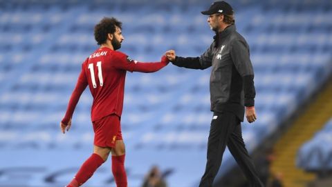 Liverpool's manager Jurgen Klopp, right, gestures with Mohamed Salah after the English Premier League soccer match between Manchester City and Liverpool at Etihad Stadium in Manchester, England, Thursday, July 2, 2020. (AP Photo/Laurence Griffiths,Pool)