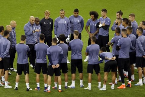 Real Madrid's head coach Zinedine Zidane, center left, gestures as he talks to his players during a training session at the Millennium Stadium in Cardiff, Wales Friday June 2, 2017. Real Madrid will play Juventus in the final of the Champions League soccer match in Cardiff on Saturday. (AP Photo/Alastair Grant)