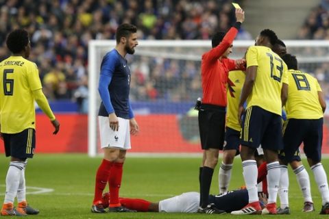 Swiss referee Adrien Jaccottet gives a yellow card to Colombia's Abel Aguilar, right, as Feyenoord's Nicolai Jorgensen , second left, looks on during a friendly soccer match between France and Colombia in Saint-Denis, outside Paris, Friday March 23, 2018. (AP Photo/Michel Euler)