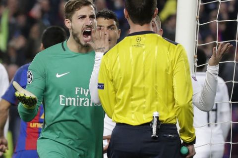 PSG goalkeeper Kevin Trapp, left, argues with the referee Deniz Ayetekin during the Champions League round of 16, second leg soccer match between FC Barcelona and Paris Saint Germain at the Camp Nou stadium in Barcelona, Spain, Wednesday March 8, 2017. (AP Photo/Emilio Morenatti)