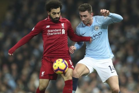 Liverpool's Mohamed Salah, left vies for the ball with Manchester City's Aymeric Laporte during their English Premier League soccer match between Manchester City and Liverpool at the Ethiad stadium, Manchester England, Thursday, Jan. 3, 2019. (AP Photo/Jon Super)