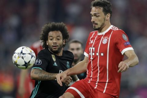 Real Madrid's Marcelo, left, and Bayern's Mats Hummels challenge for the ball during the semifinal first leg soccer match between FC Bayern Munich and Real Madrid at the Allianz Arena stadium in Munich, Germany, Wednesday, April 25, 2018. (AP Photo/Matthias Schrader)