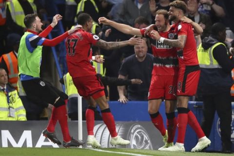Huddersfield Town's Laurent Depoitre, second right, celebrates scoring against Chelsea with teammates during the English Premier League soccer match at Stamford Bridge, London, Wednesday May 9, 2018. (John Walton/PA via AP)