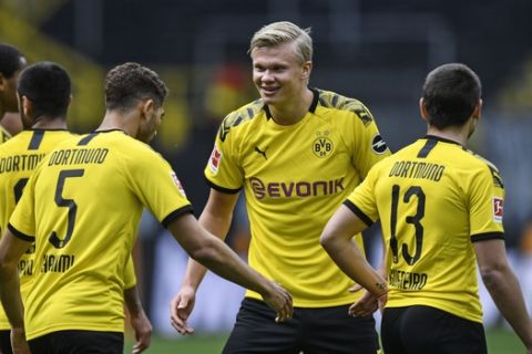 Dortmund's Erling Haaland, center, celebrates after his team scored the 4th goal during the German Bundesliga soccer match between Borussia Dortmund and Schalke 04 in Dortmund, Germany, Saturday, May 16, 2020. The German Bundesliga becomes the world's first major soccer league to resume after a two-month suspension because of the coronavirus pandemic. (AP Photo/Martin Meissner, Pool)