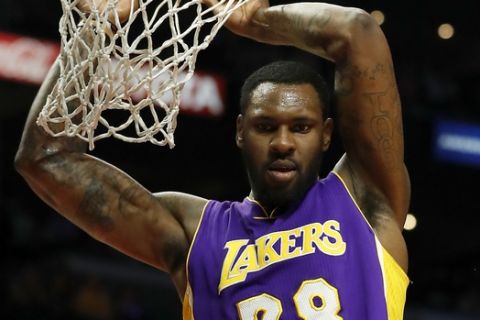 Los Angeles Lakers center Tarik Black, top, looks at Los Angeles Clippers guard JJ Redick, bottom, after dunking during the second half of an NBA basketball game, Saturday, April 1, 2017, in Los Angeles. (AP Photo/Ryan Kang)