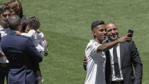 Brazilian player Rodrygo Goes, second right, takes a snapshot with former Brazilian player Roberto Carlos during his official presentation after signing for Real Madrid at the Santiago Bernabeu stadium in Madrid, Spain, Tuesday, June 18, 2019. (AP Photo/Manu Fernandez)