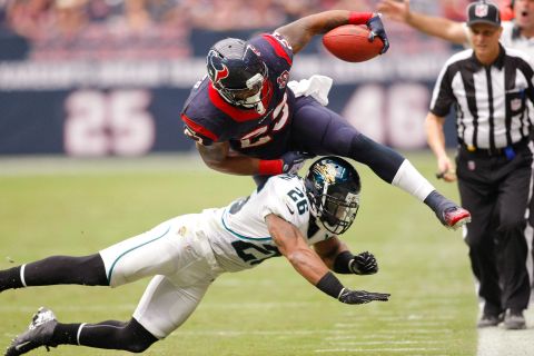 Nov 18, 2012; Houston, TX, USA; Houston Texans running back Arian Foster (23) is tackled by Jacksonville Jaguars strong safety Dawan Landry (26) in the third quarter at Reliant Stadium. The Texans defeated the Jaguars 43-37. Mandatory Credit: Brett Davis-US PRESSWIRE

