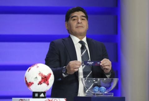 Argentina's former soccer player Diego Maradona holds up the name of Uruguay during the official draw for the FIFA U-20 World Cup Korea 2017 in Suwon, South Korea, Wednesday, March 15, 2017. The FIFA U-20 World Cup Korea 2017 matches will be held in six South Korean cities from May 20 to June 11. (AP Photo/Lee Jin-man)