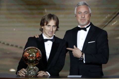 Real Madrid's Luka Modric, left, poses with David Ginola after receiving the Ballon d'Or award during the Golden Ball award ceremony at the Grand Palais in Paris, France, Monday, Dec. 3, 2018. Awarded every year by France Football magazine since Stanley Matthews won it in 1956, the Ballon d'Or, Golden Ball for the best player of the year will be given to both a woman and a man. (AP Photo/Christophe Ena)