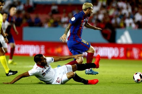 Sevilla's Gabriel Mercado, left, tries to tackle Barcelona's Lionel Messi during the Spanish Super Cup first-leg soccer match at Ramon Sanchez-Pizjuan stadium in Seville, Spain, Sunday, Aug. 14, 2016. (AP Photo/Antonio Pizarro)