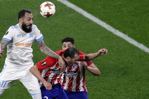 Marseille's Konstantinos Mitroglou, left, heads the ball during the Europa League Final soccer match between Marseille and Atletico Madrid at the Stade de Lyon outside Lyon, France, Wednesday, May 16, 2018. (AP Photo/Christophe Ena)