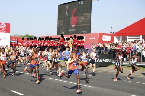 Mo Farah, center, runs at the start of the London Marathon in central London, Sunday, April 22, 2018, passing a video screen showing Britain's Queen Elizabeth II pressing a button in Windsor Castle, that started the race. (Adam Davy/PA via AP)
