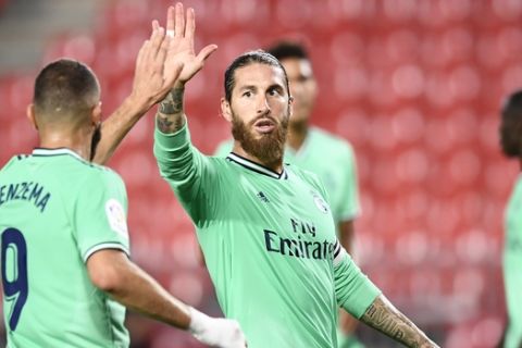 Real Madrid's Sergio Ramos, center, gestures with his teammate Benzema during the Spanish La Liga soccer match between Granada and Real Madrid at the Los Carmenes stadium in Granada, Spain, Monday, July 13, 2020. (AP Photo/Jose Breton)