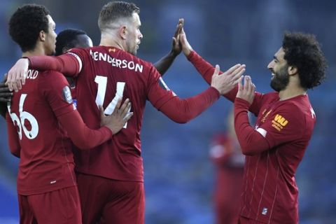 Liverpool's Mohamed Salah, right, is congratulated by teammates after scoring his team's first goal during the English Premier League soccer match between Brighton and Liverpool at Falmer Stadium in Brighton, England, Wednesday, July 8, 2020. (AP Photo/Daniel Leal Olivas,Pool)