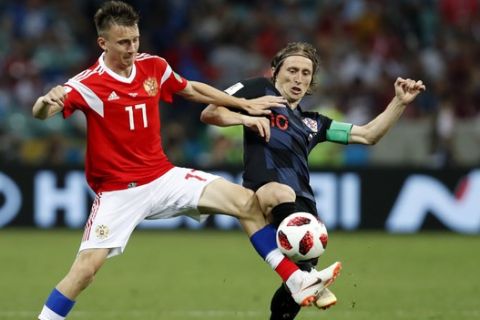 Russia's Alexander Golovin, left, duels for the ball with Croatia's Luka Modric during the quarterfinal match between Russia and Croatia at the 2018 soccer World Cup in the Fisht Stadium, in Sochi, Russia, Saturday, July 7, 2018. (AP Photo/Rebecca Blackwell)