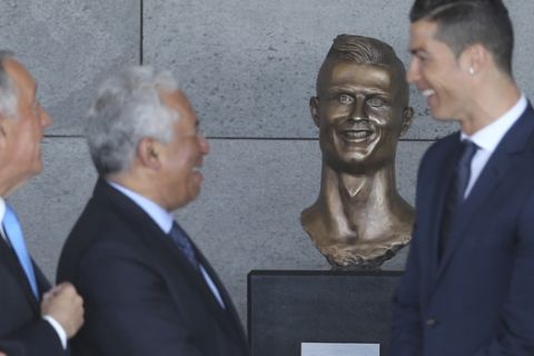 Portuguese president Marcelo Rebelo de Sousa, left, Portuguese Prime Minister Antonio Costa, 2nd left and Real Madrid's Cristiano Ronaldo stand next to a bust of the player at the Madeira international airport outside Funchal, the capital of Madeira island, Portugal, Wednesday March 29, 2017. Madeira International Airport has been renamed after local soccer star Cristiano Ronaldo on Wednesday during a ceremony, with family, at the airport outside his Funchal hometown. (AP Photo/Armando Franca)