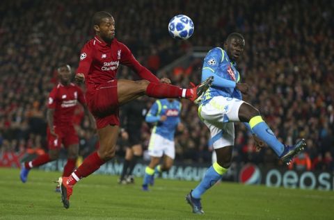 Liverpool midfielder Georginio Wijnaldum, left, and Napoli defender Kalidou Koulibaly challenge for the ball during the Champions League Group C soccer match between Liverpool and Napoli at Anfield stadium in Liverpool, England, Tuesday, Dec. 11, 2018.(AP Photo/Dave Thompson)