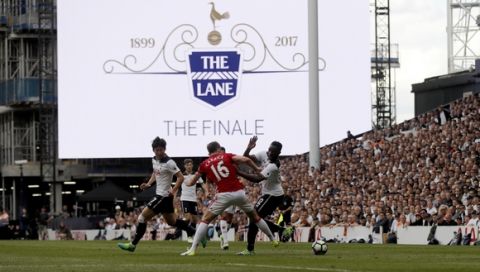 Tottenham's Victor Wanyama, right, vies for the ball with Manchester United's Michael Carrick below a display screen during the English Premier League soccer match between Tottenham Hotspur and Manchester United at White Hart Lane stadium in London, Sunday, May 14, 2017. It is the last Spurs match at the old stadium, a new stadium is being built on the site. (AP Photo/Frank Augstein)