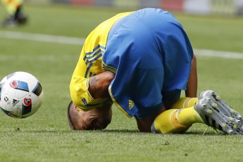 Sweden's Mikael Lustig lies on the pitch in pain after a challenge, during the Euro 2016 Group E soccer match between Ireland and Sweden at the Stade de France in Saint-Denis, north of Paris, France, Monday, June 13, 2016. (AP Photo/Christophe Ena)