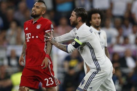 Real Madrid's Sergio Ramos pushes Bayern's Arturo Vidal off the pitch after he was shown a red card during the Champions League quarterfinal second leg soccer match between Real Madrid and Bayern Munich at Santiago Bernabeu stadium in Madrid, Spain, Tuesday April 18, 2017. (AP Photo/Francisco Seco)