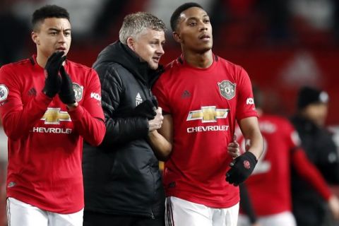 Manchester United manager Ole Gunnar Solskjaer, center, and Anthony Martial, right, talk after the English Premier League soccer match between Manchester United and Wolverhampton Wanderers, at Old Trafford, in Manchester, England, Saturday, Feb. 1, 2020. (Martin Rickett/PA via AP)