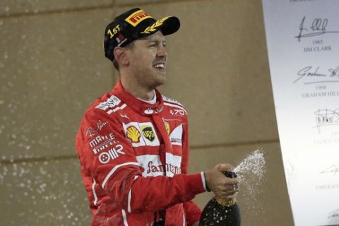 Ferrari driver Sebastian Vettel of Germany celebrates on the podium after winning the Bahrain Formula One Grand Prix, at the Formula One Bahrain International Circuit in Sakhir, Bahrain, Sunday, April 16, 2017. (AP Photo/Hassan Ammar)