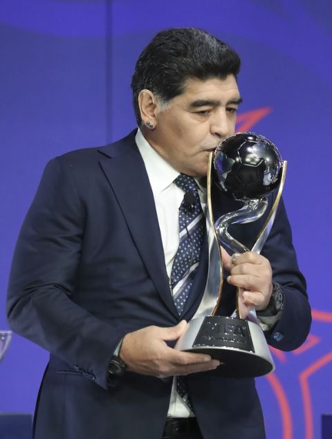 Argentina's former soccer player Diego Maradona kisses the FIFA U-20 World Cup trophy upon his arrival for the official draw for the FIFA U-20 World Cup Korea 2017 in Suwon, South Korea, Wednesday, March 15, 2017. The FIFA U-20 World Cup Korea 2017 matches will be held in six South Korean cities from May 20 to June 11. (AP Photo/Lee Jin-man)