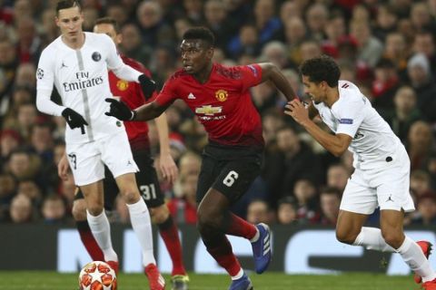 Manchester United's Paul Pogba, centre, vies for the ball with Paris Saint Germain's Marcos Marquinhos, right, during the Champions League round of 16 soccer match between Manchester United and Paris Saint Germain at Old Trafford stadium in Manchester, England, Tuesday, Feb. 12,2019.(AP Photo/Dave Thompson)