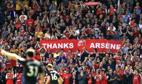 Arsenal fans carry banners supporting outgoing manager Arsene Wenger in the stands before the English Premier League soccer match between Huddersfield Town and Arsenal at the John Smith's Stadium, Huddersfield, England, Sunday, May 13, 2018. (Mike Egerton/PA via AP)