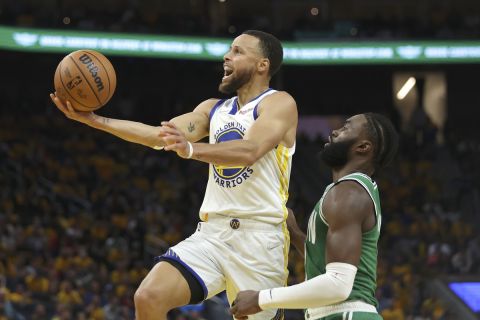 Stephen Curry, de Warriors de Golden State, dispara en contra de Jaylen Brown, de los Celtics de Boston, durante la segunda mitad del juego de baloncesto en las Finales de la NBA, en San Francisco, el jueves 2 de junio de 2022. (AP Foto/Jed Jacobsohn)